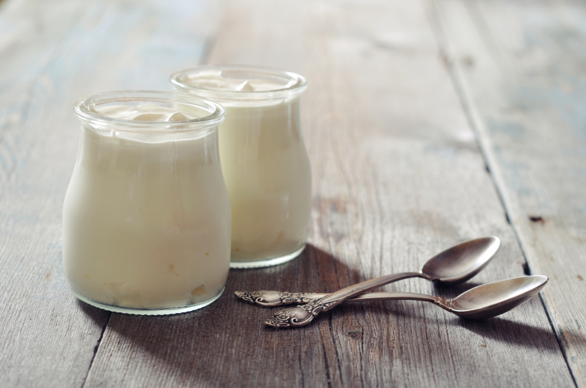 Greek Yogurt In A Glass Jars With Spoons On Wooden Background